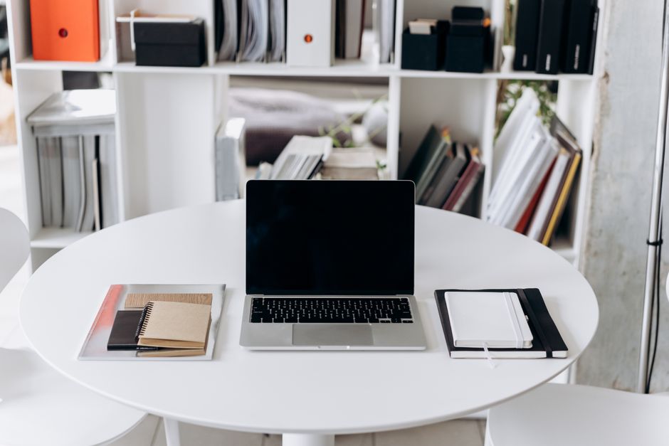 Um elegante ambiente de escritório com um laptop, cadernos e móveis estilosos, ideal para produtividade.