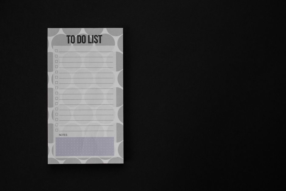 Um bloco de notas minimalista de lista de tarefas com espaço em branco em um fundo preto, ideal para temas de produtividade.
