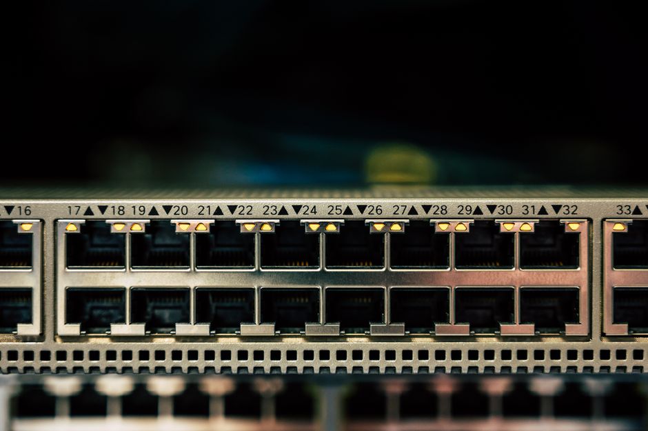 Vista detalhada de um switch de rede com múltiplas portas ethernet e indicadores LED.