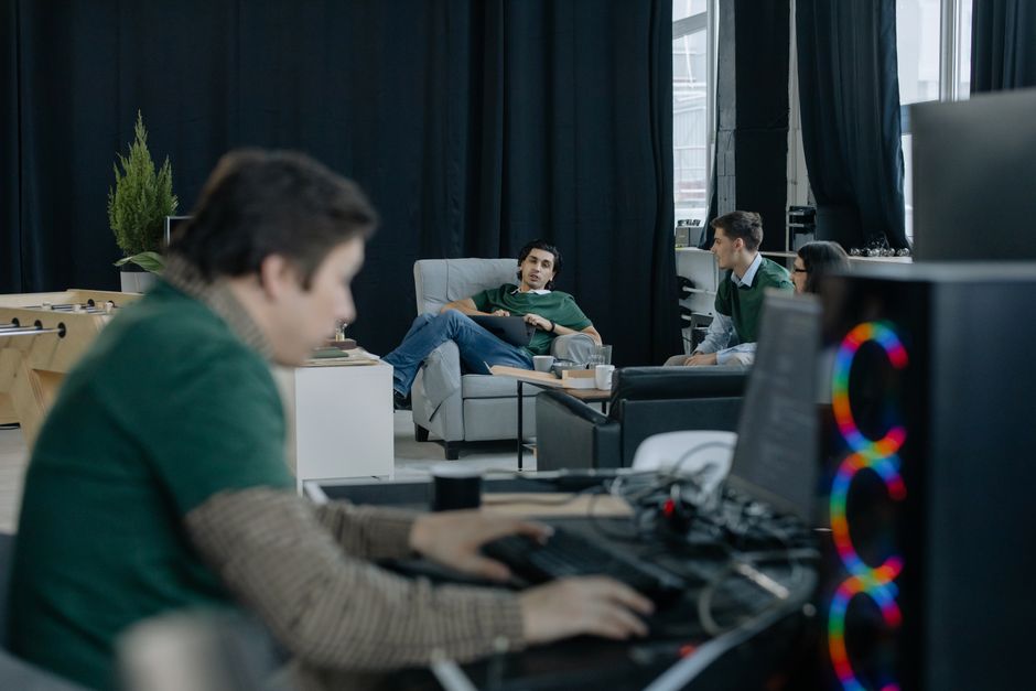 Grupo focado de profissionais em um escritório moderno discutindo ideias e trabalhando colaborativamente.